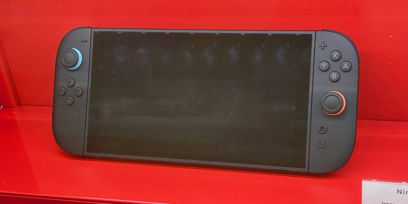 Nintendo Switch 2 console with Joy-Con 2 controllers in handheld mode on a red display