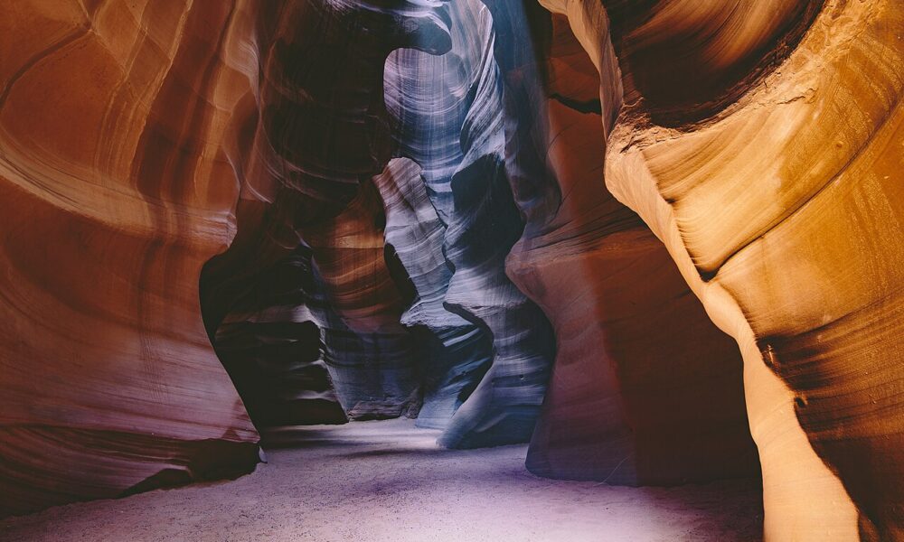 Real photograph of sunlight falling across sculpted sandstone walls inside Antelope Canyon near Page, Arizona