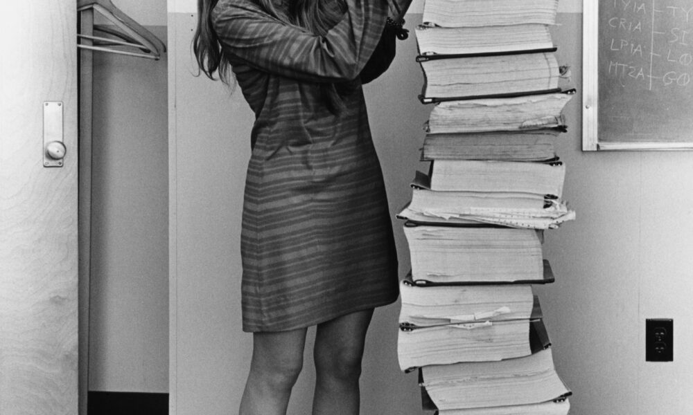 Margaret Hamilton beside Apollo program software printouts in 1969.