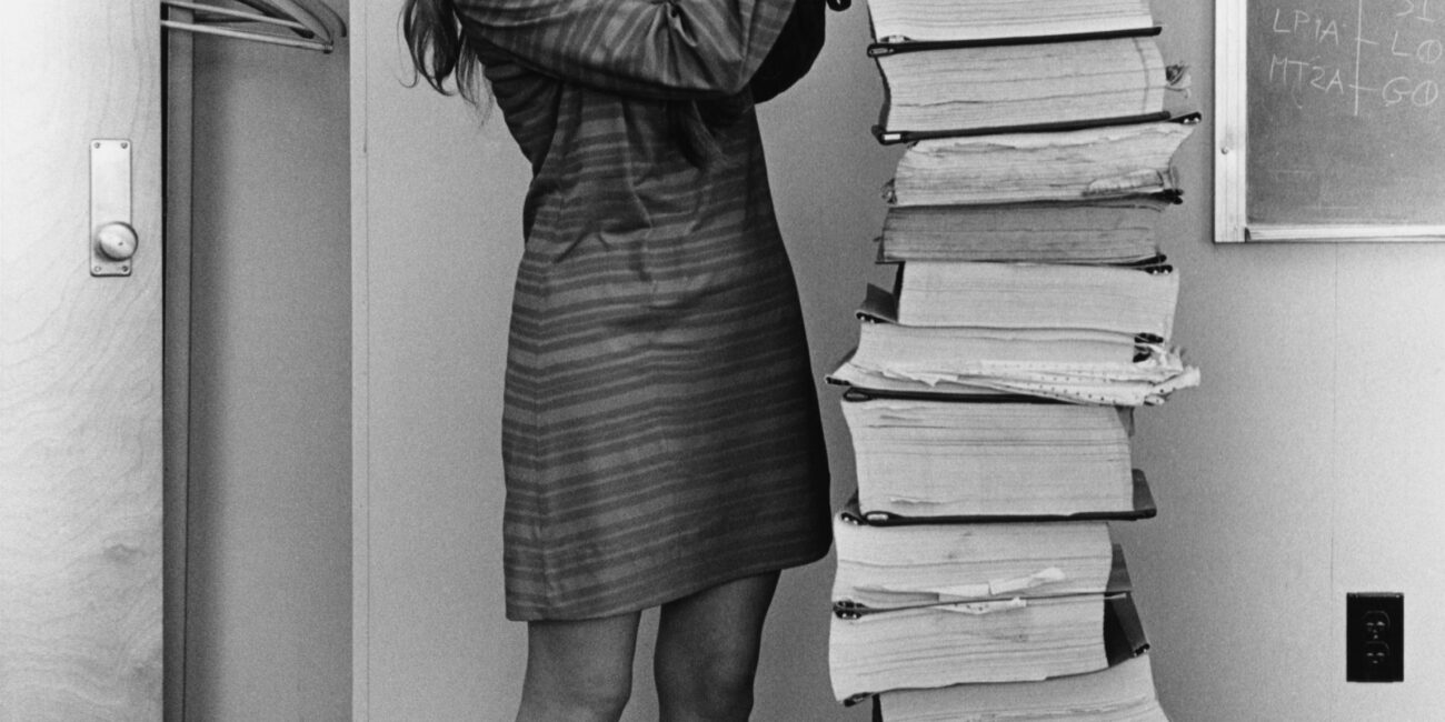 Margaret Hamilton beside Apollo program software printouts in 1969.