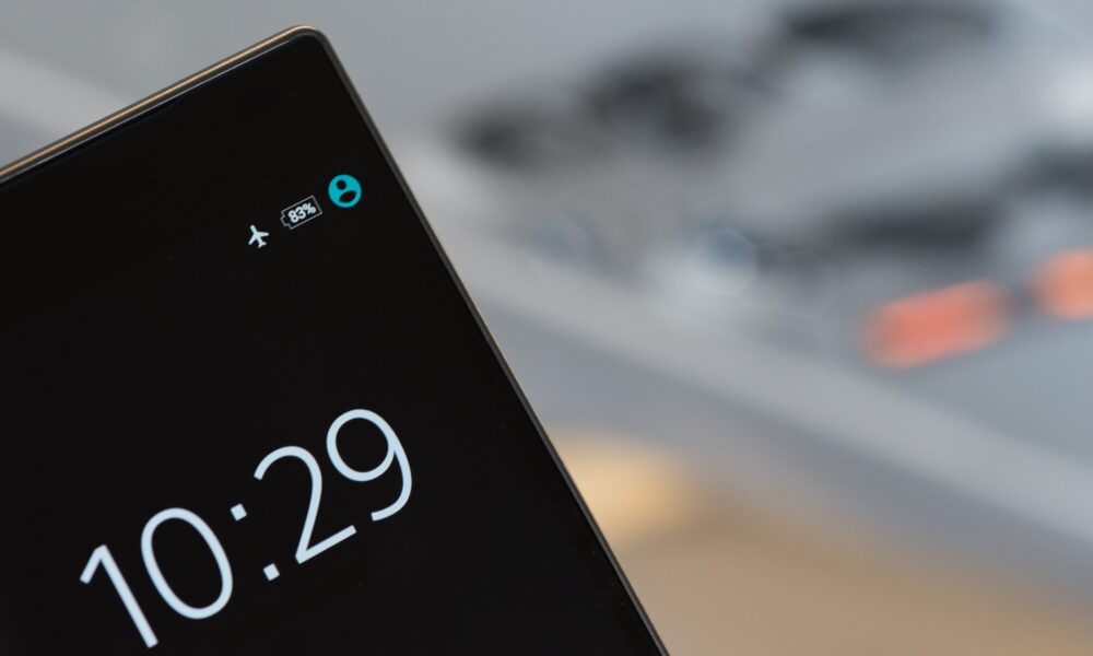 Close-up photograph of a smartphone display with an airplane mode indicator among its status icons