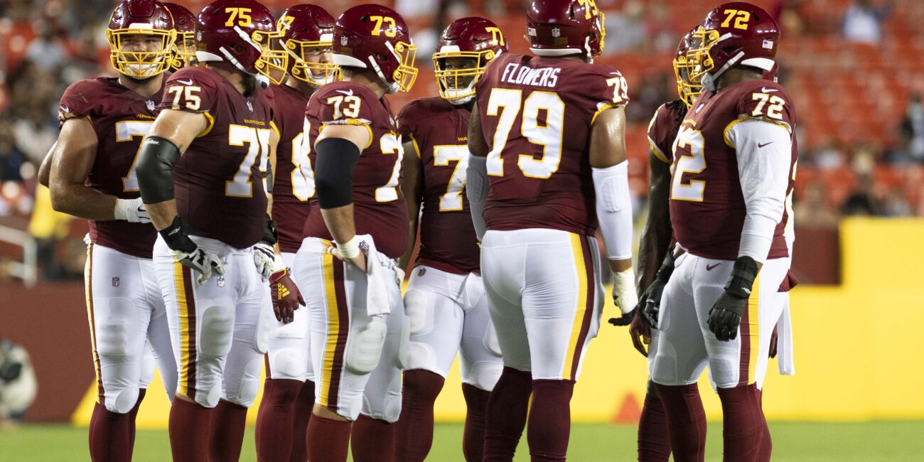 Washington Football Team offensive linemen line up before a snap against the Cincinnati Bengals in August 2021