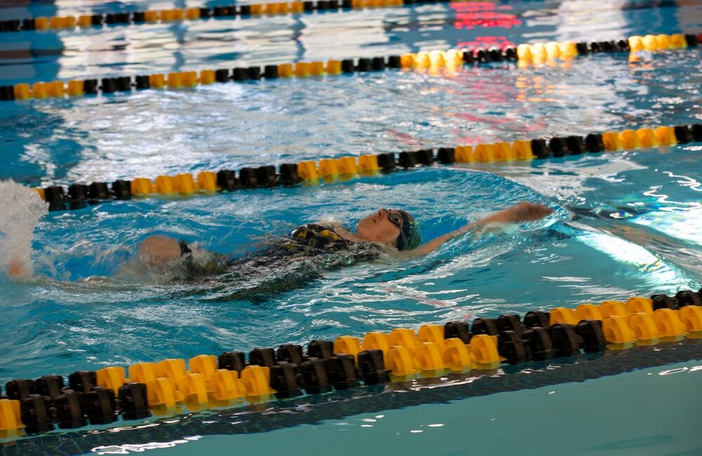 Navy swimmer competing in the women's backstroke event at the 2025 Warrior Games