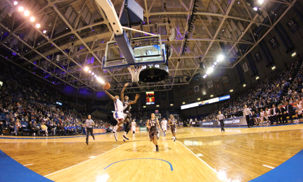Basketball player shooting a layup near the basket in a game