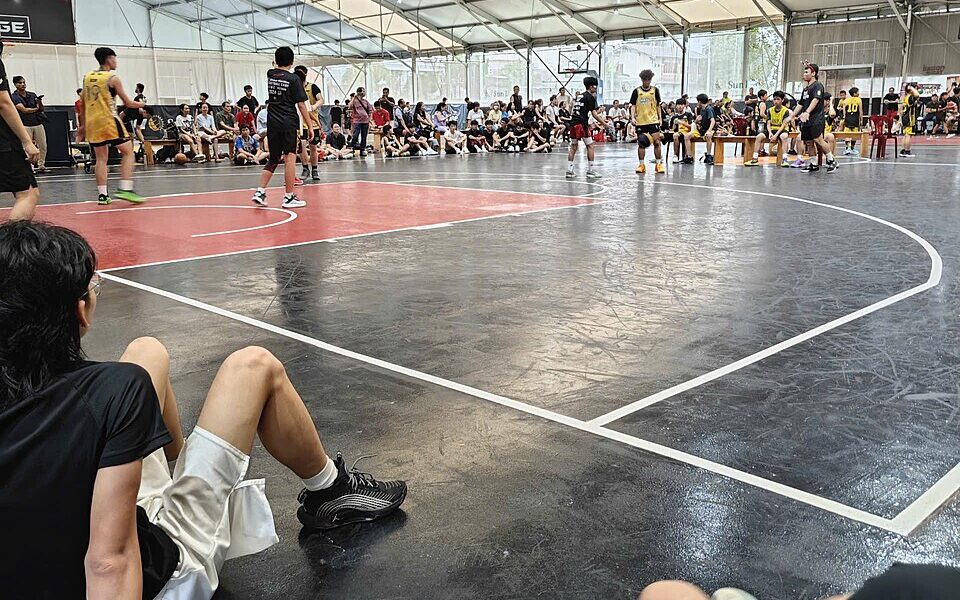 Full-sized basketball court photographed from the sideline