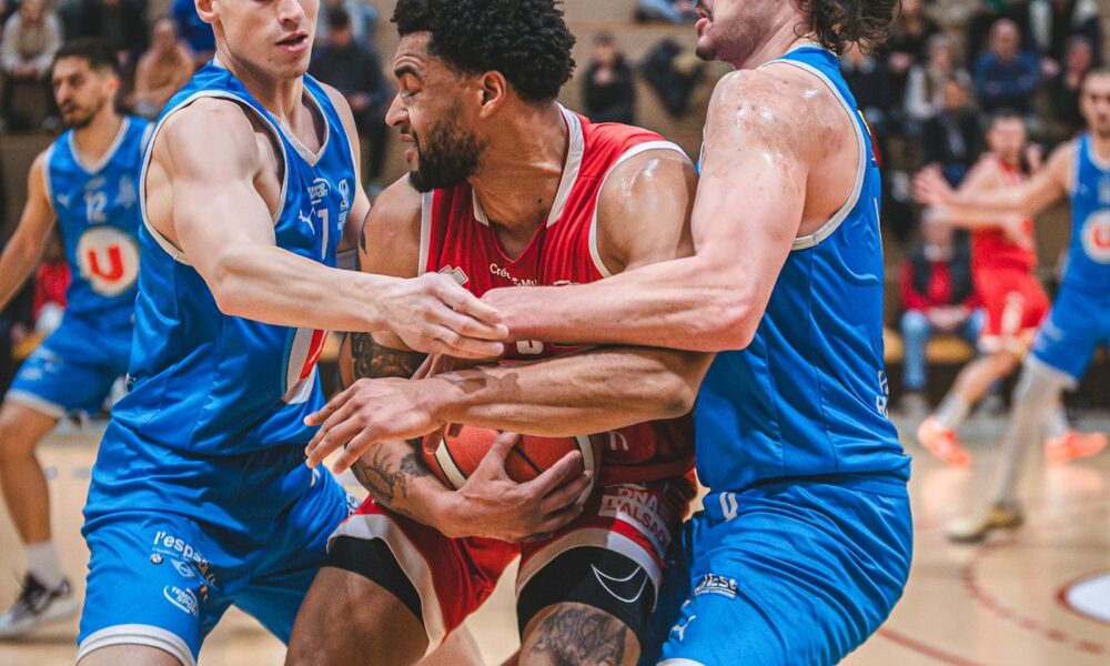 Two basketball players contesting the ball during a live defensive match-up on an indoor court