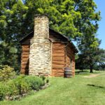 Reconstructed kitchen cabin, stone chimney and bell at Booker T. Washington National Monument in Virginia