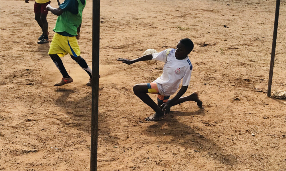 Football goalkeeper saving an incoming shot during a match, illustrating the aim of a clean sheet