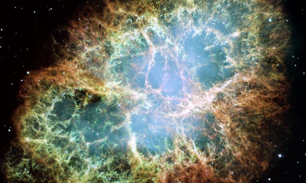 Real Hubble Space Telescope image of Crab Nebula M1 supernova remnant with glowing filament shell and central pulsar region