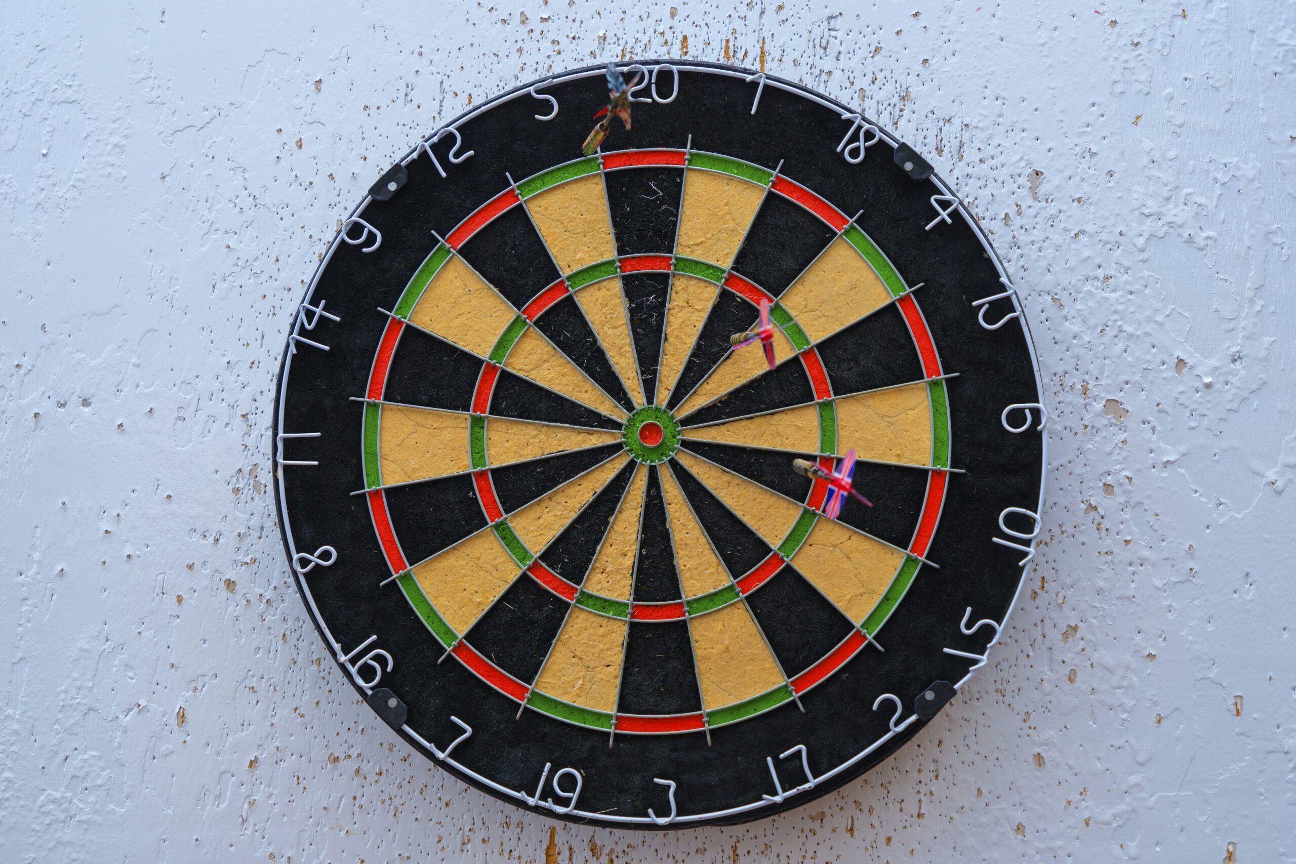 Real steel-tip dartboard with darts embedded in numbered segments