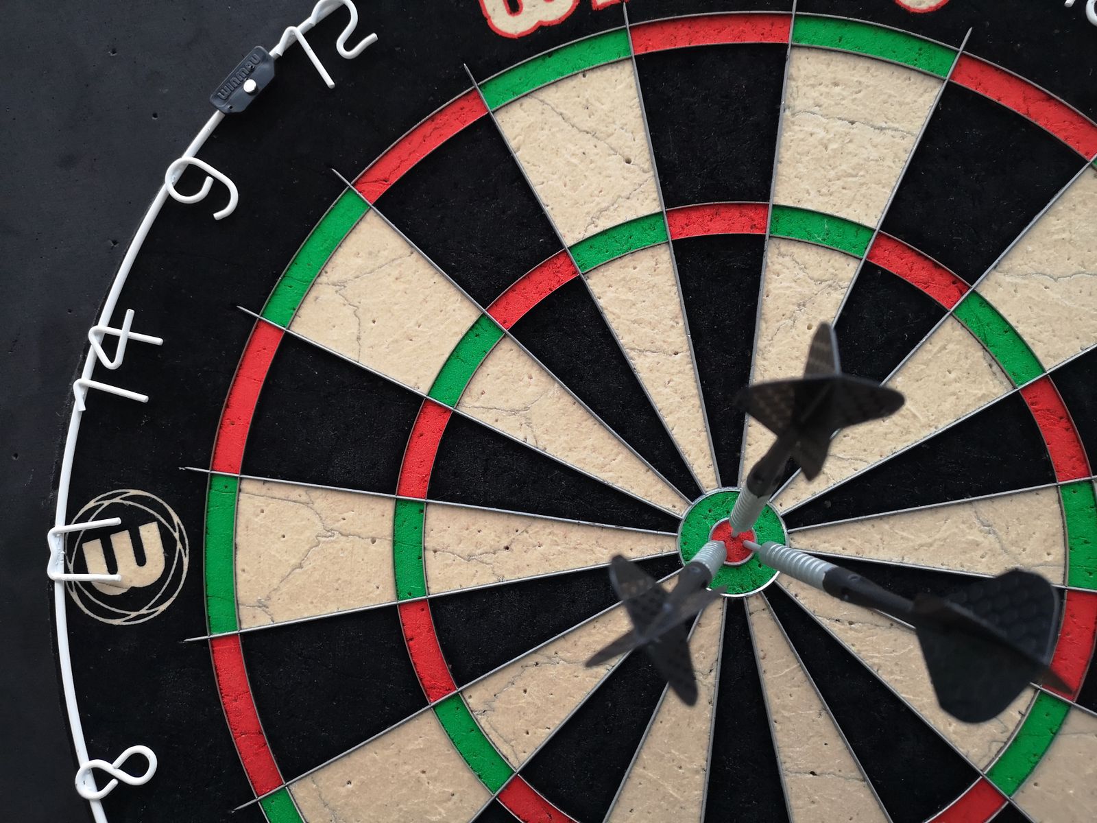 Actual dartboard showing darts grouped around the bullseye
