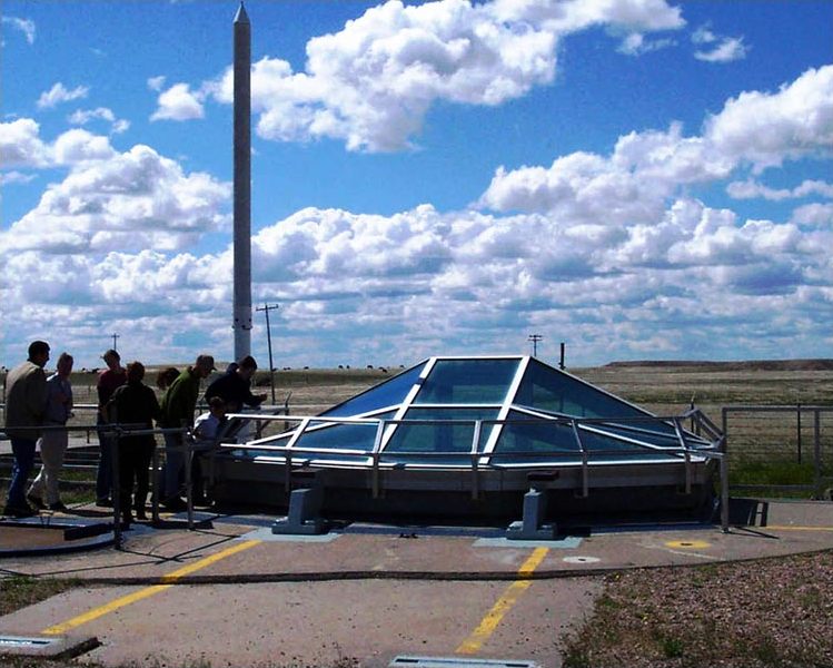 Real visitors looking through a glass viewing enclosure at the Delta-09 missile silo in South Dakota