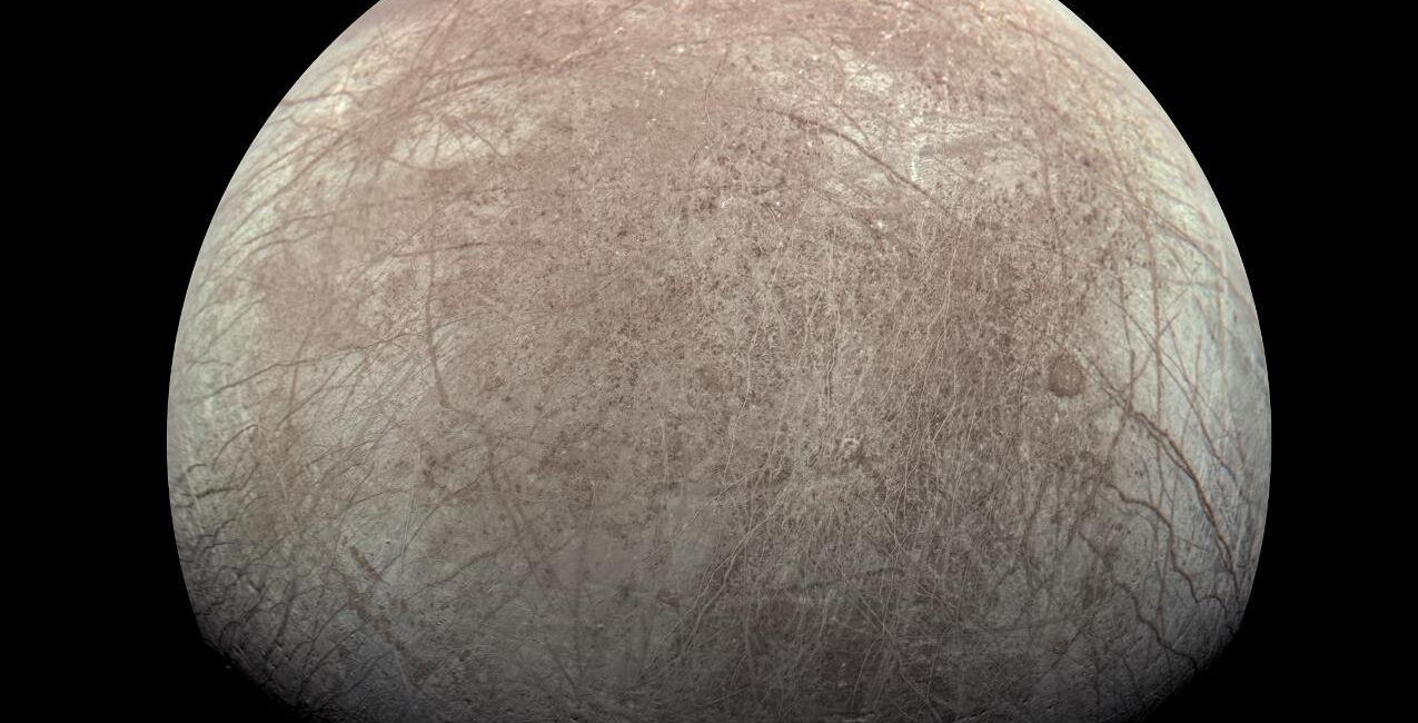 Actual NASA Juno JunoCam spacecraft photo of Europa's icy round moon showing long reddish-brown cracks during Sept 29 2022 flyby
