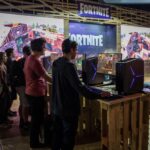 Players using Fortnite at Gamescom 2017 illustrating the ping and network debug stats guide