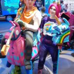 Two Fortnite fans wearing colorful homemade cosplay and llama-themed props at a 2019 gaming convention
