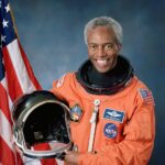 Actual NASA 1992 photograph of astronaut Guion Bluford holding his launch helmet in a flight suit