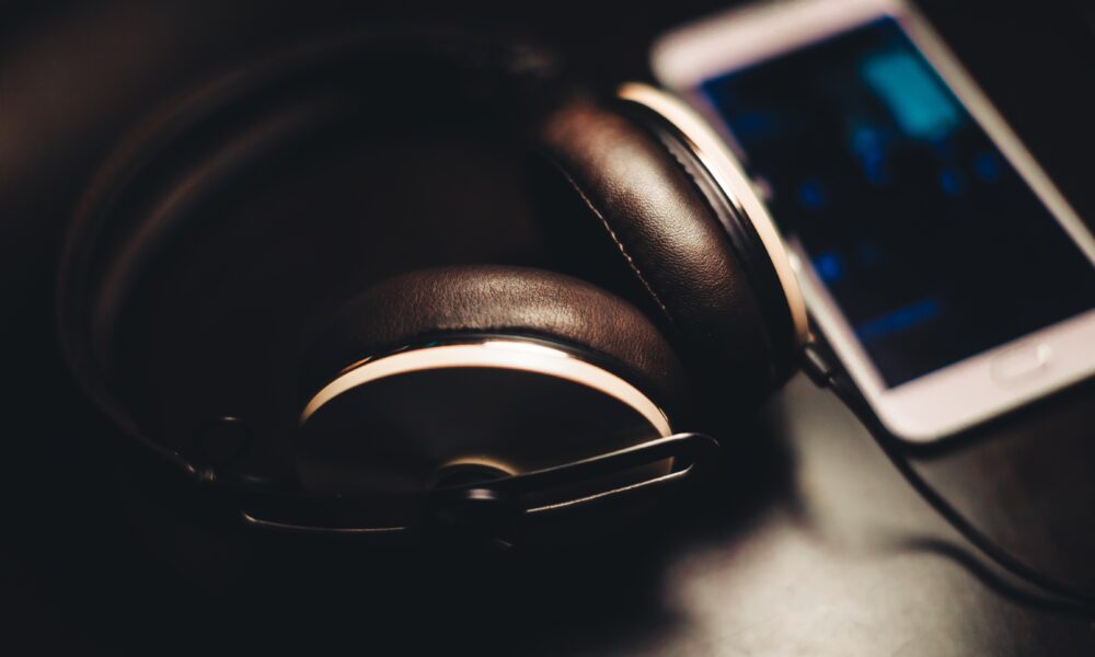 Real photograph of headphones next to a smartphone