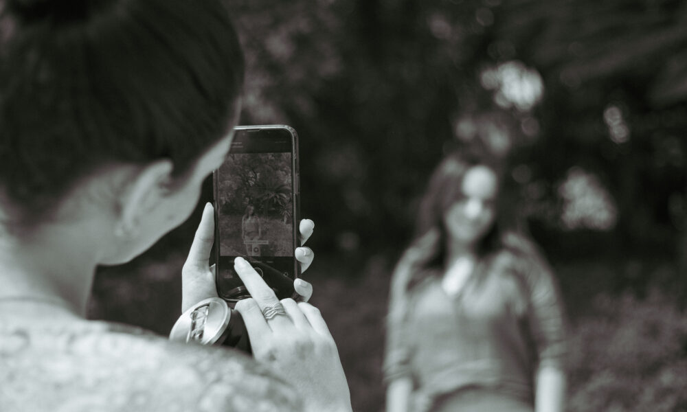 Photographer composing a smartphone portrait for a social media post