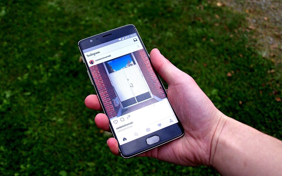 Photograph of an Instagram application displayed on a phone with a grassy background; illustrative privacy guide