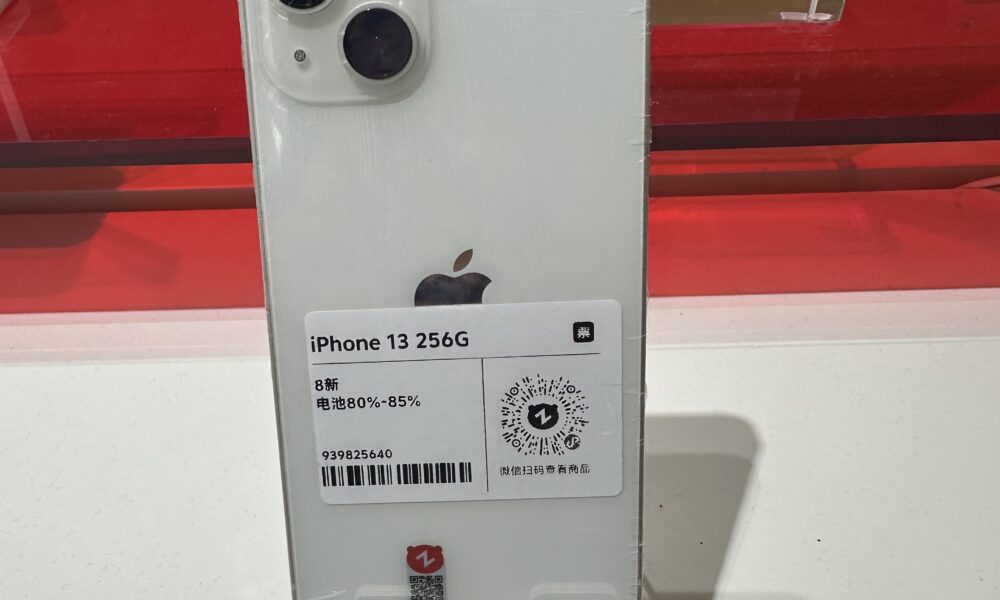 Photograph of a white iPhone 13, illustrating the device used in an iPhone factory-reset walkthrough