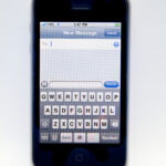 Close-up of the on-screen keyboard on an older white iPhone 3G, an illustrative device photo rather than a current iOS settings screen