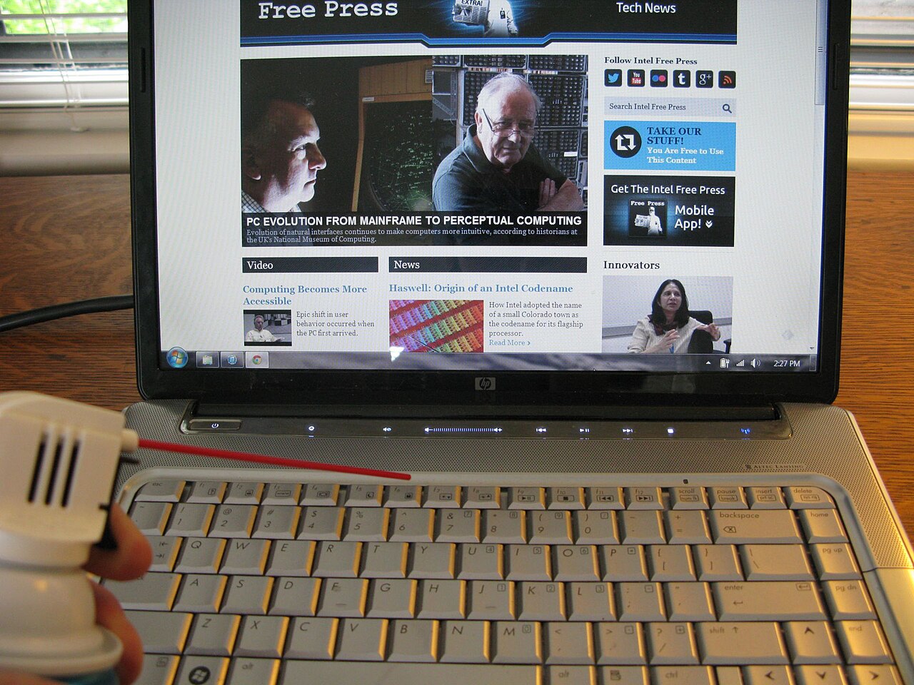 Compressed air directed across a real laptop keyboard to remove dust
