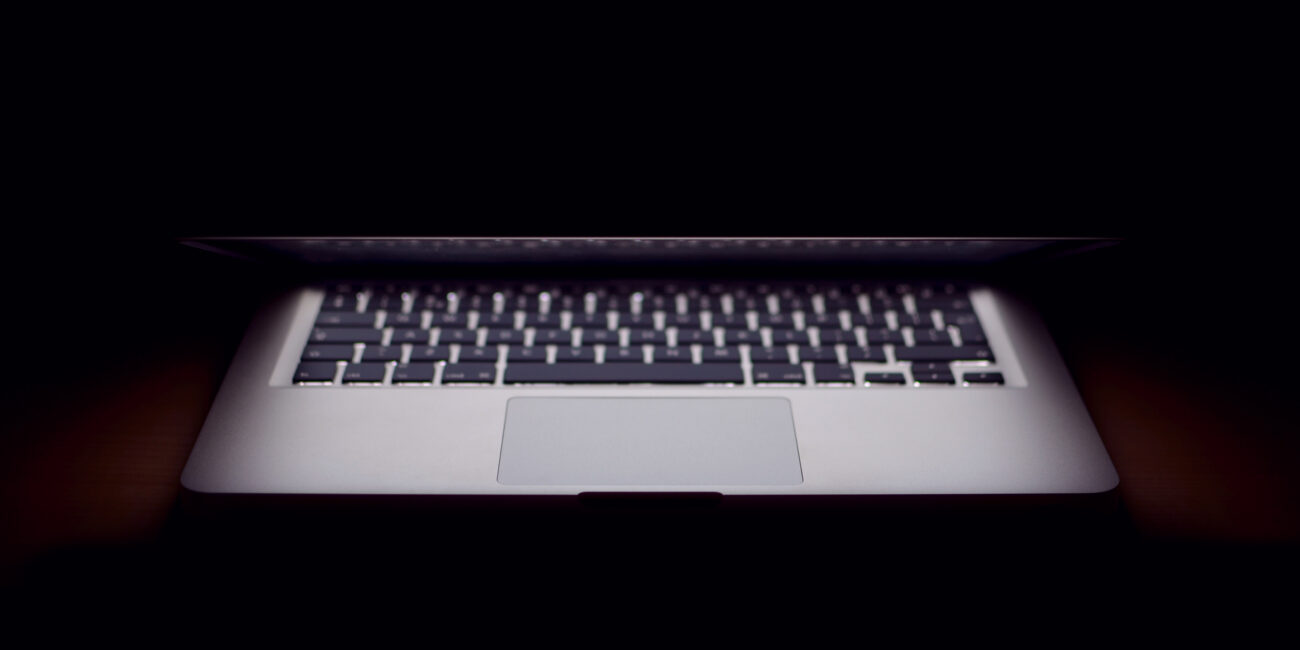 Real laptop with a partly closed display resting on a desk