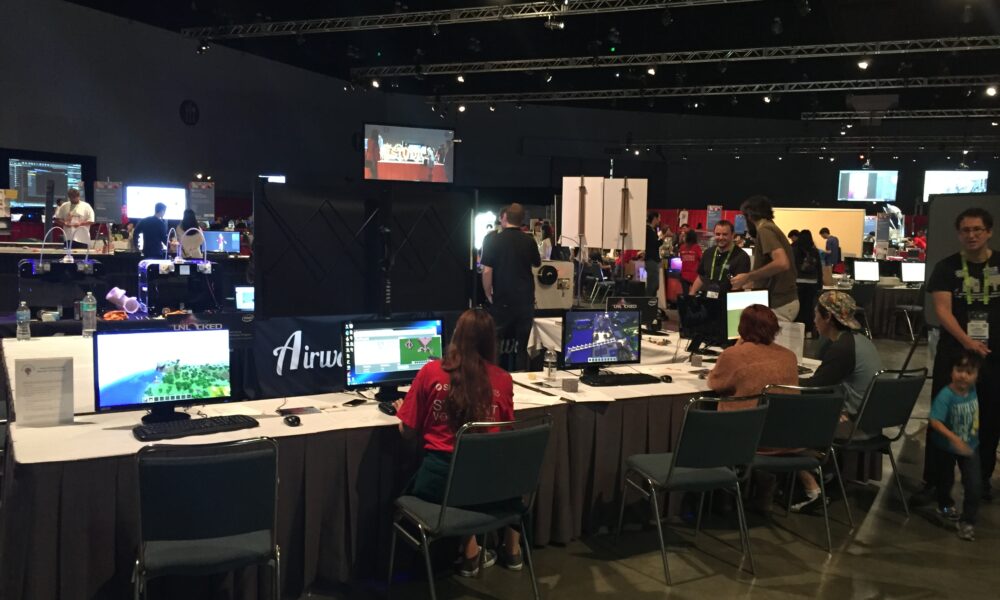 Person playing Minecraft on a computer at SIGGRAPH showing a block-based game scene