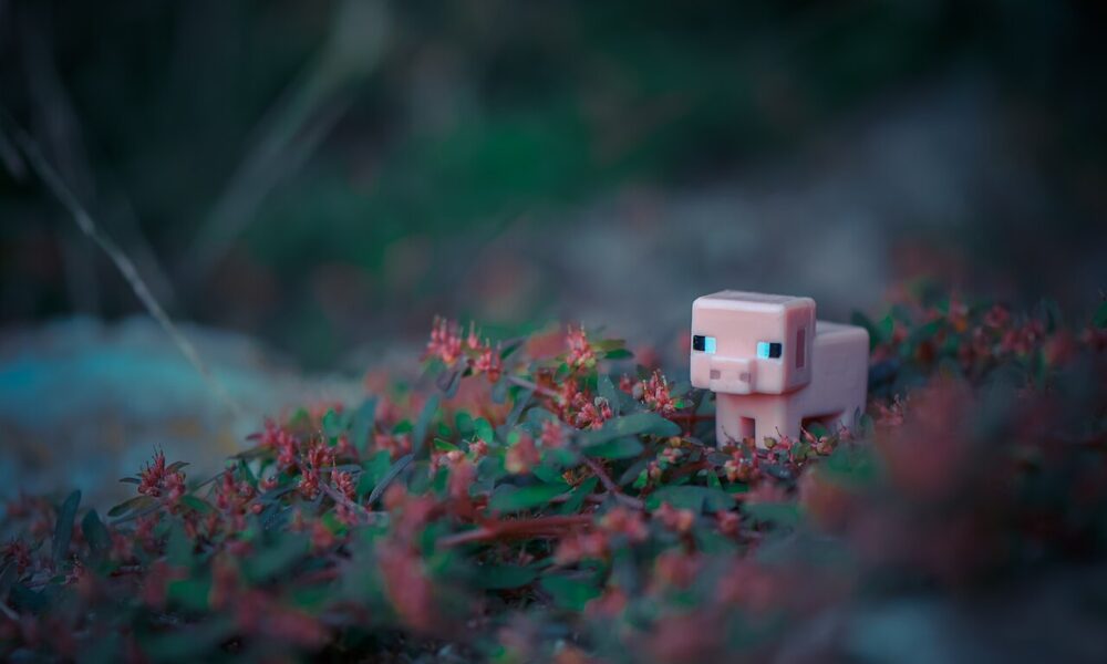 A real photograph of a Minecraft pig miniature toy, visually representing the pig mob in a Minecraft breeding guide