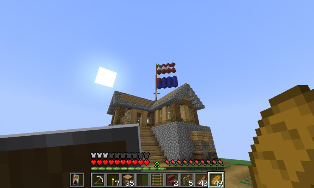 Minecraft Survival gameplay screenshot of a player-built wood-and-stone house with a pitched roof and exterior stairs