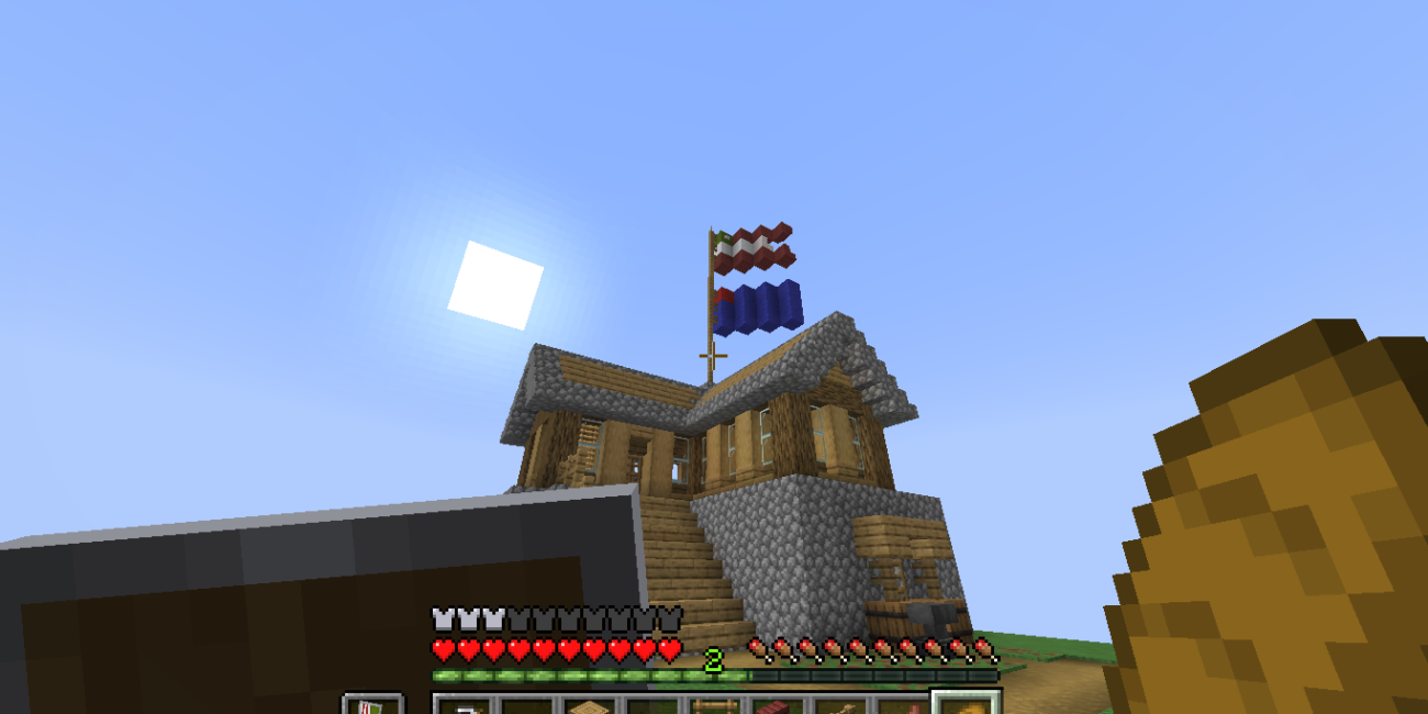Minecraft Survival gameplay screenshot of a player-built wood-and-stone house with a pitched roof and exterior stairs