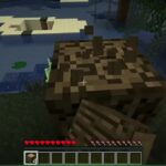 Minecraft Survival gameplay showing a player chopping a tree near water while collecting wood