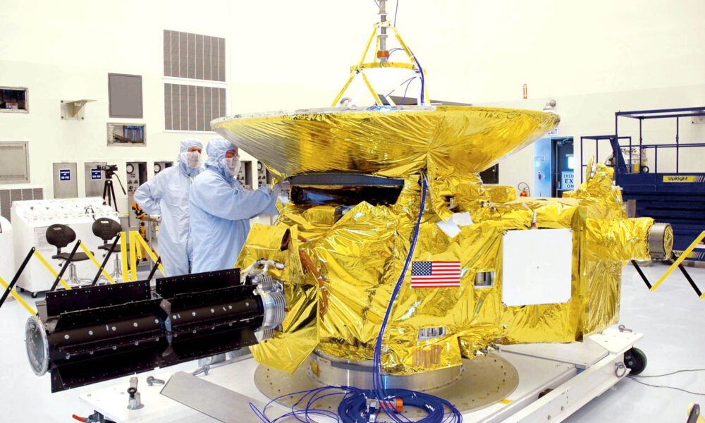 Real New Horizons spacecraft at NASA Kennedy Space Center in November 2005, showing golden thermal blankets and dish antenna