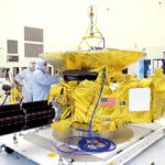 Real New Horizons spacecraft at NASA Kennedy Space Center in November 2005, showing golden thermal blankets and dish antenna