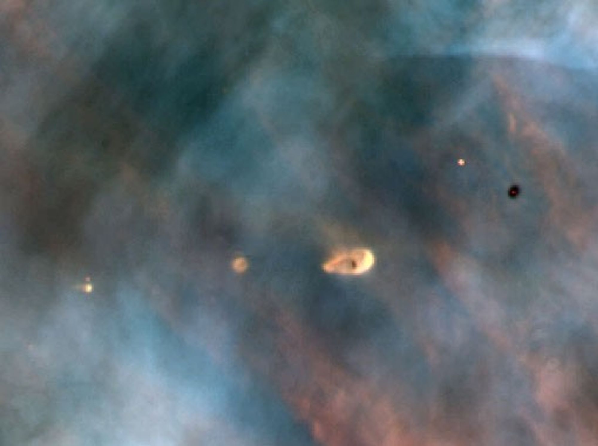 Real Hubble 1993 close-up photo in the Orion Nebula showing five young stars and protoplanetary disks or proplyds in glowing gas