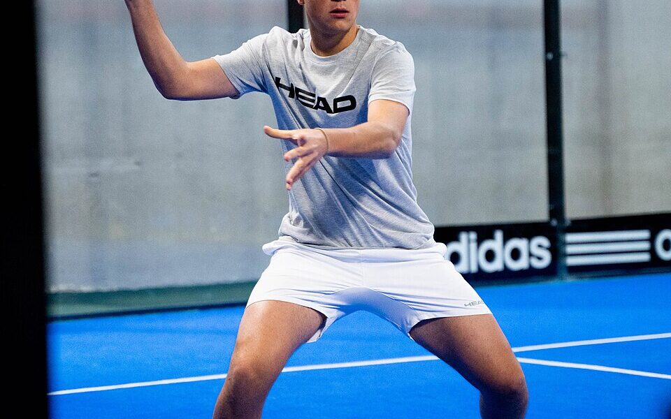 Padel player Fran Guerrero playing a shot on court
