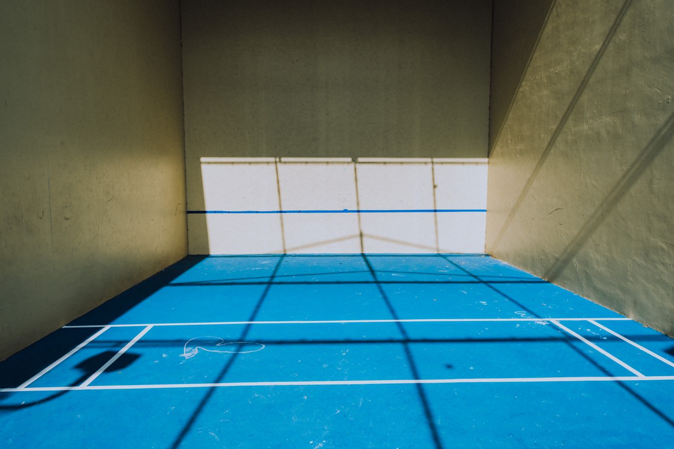 Actual blue outdoor pickleball court surface with white markings and a net