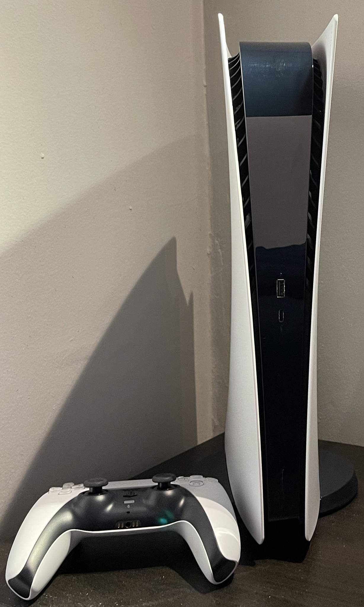 Real PlayStation 5 Digital Edition console and DualSense controller showing exterior surfaces for cleaning