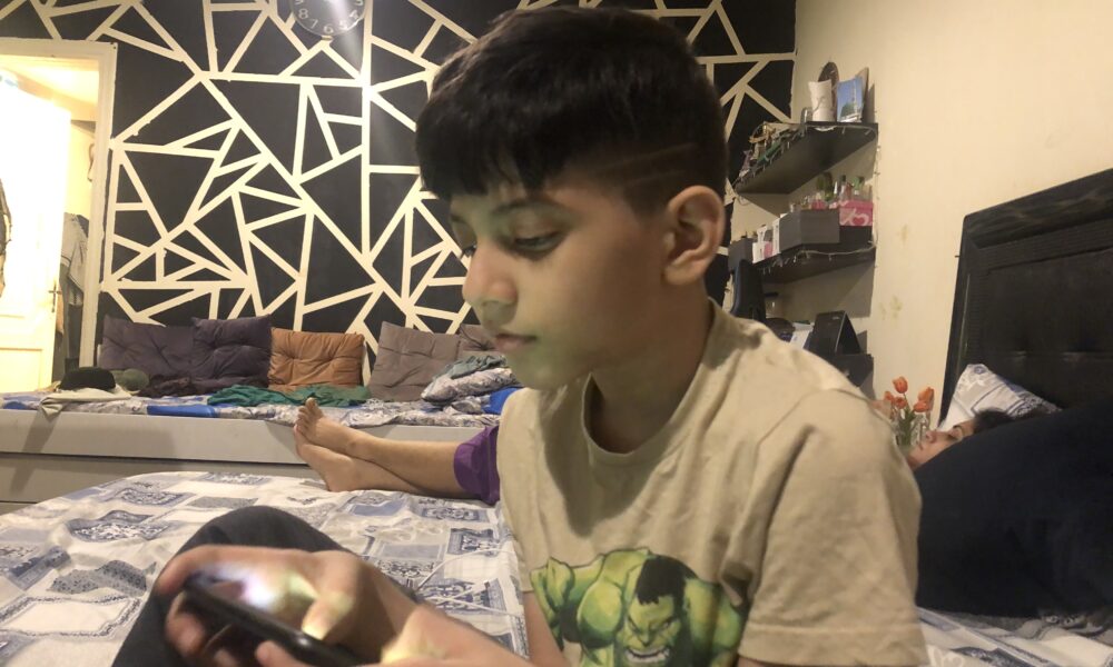 Real photo of a child playing Roblox on a screen