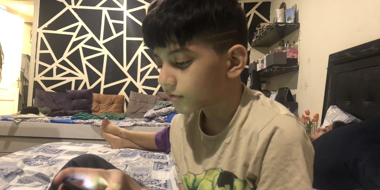 Real photo of a child playing Roblox on a screen