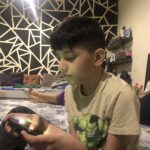Real photo of a child playing Roblox on a screen