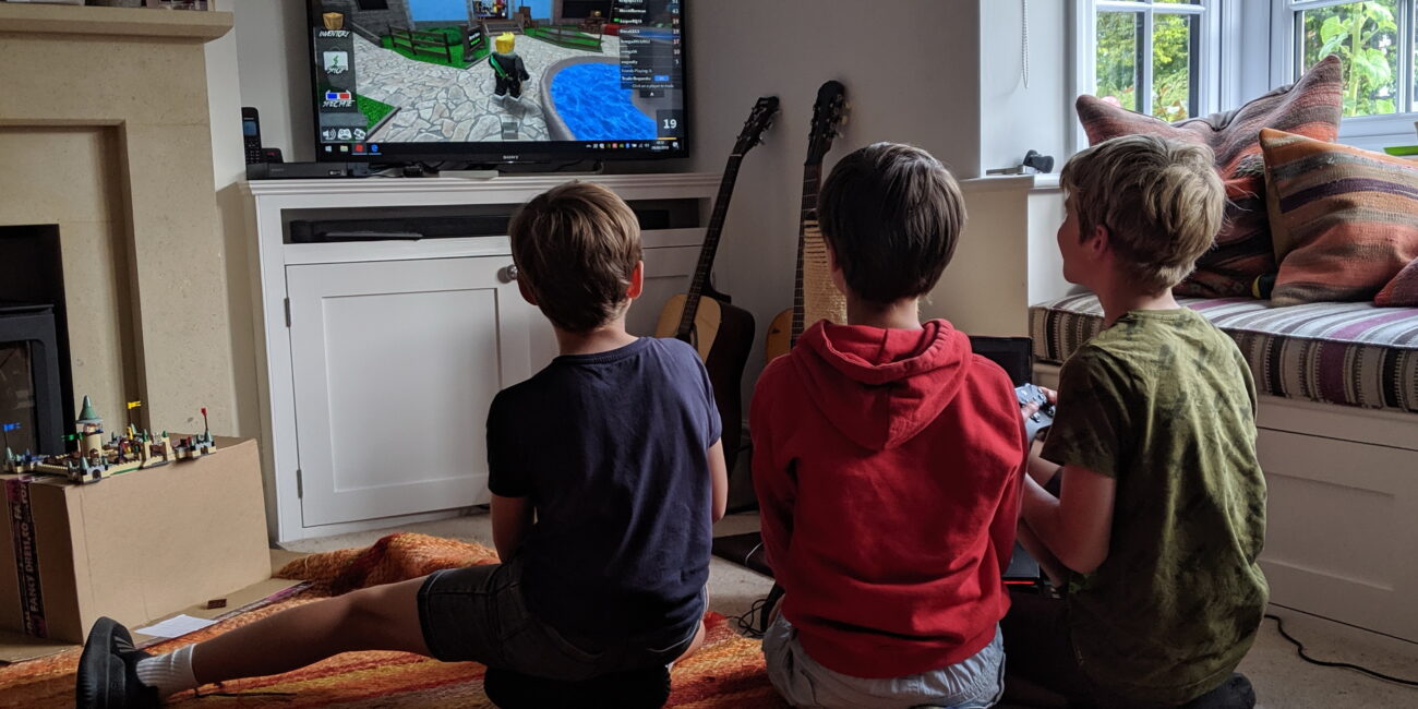 Real photograph of children playing Roblox on gaming devices