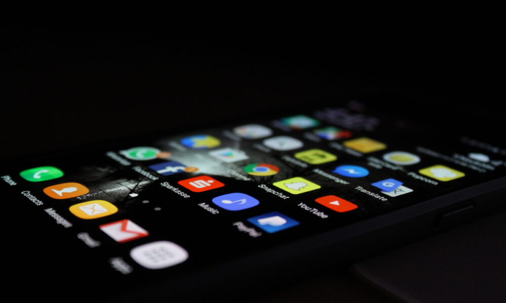 Close-up photograph of a Samsung Galaxy phone displaying its home screen with app icons