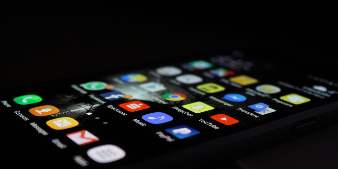 Close-up photograph of a Samsung Galaxy phone displaying its home screen with app icons