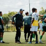 Soccer coach giving instructions to teammates during training