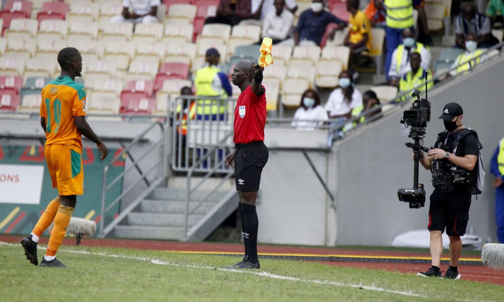 Assistant referee holding a flag during a football match, illustrating the offside rule