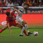 Two soccer players contesting possession in a one-versus-one defending duel