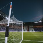 Soccer goal net at a stadium, illustrating how an own goal is recorded