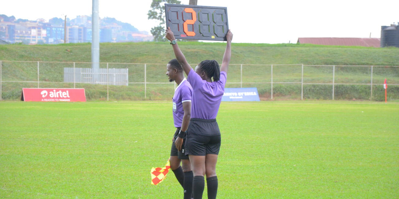 Fourth official holding an electronic substitution board during a soccer match