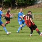Lucas Baker of Foley Meir sends a through pass behind Telford Town defenders toward striker Jay Finney